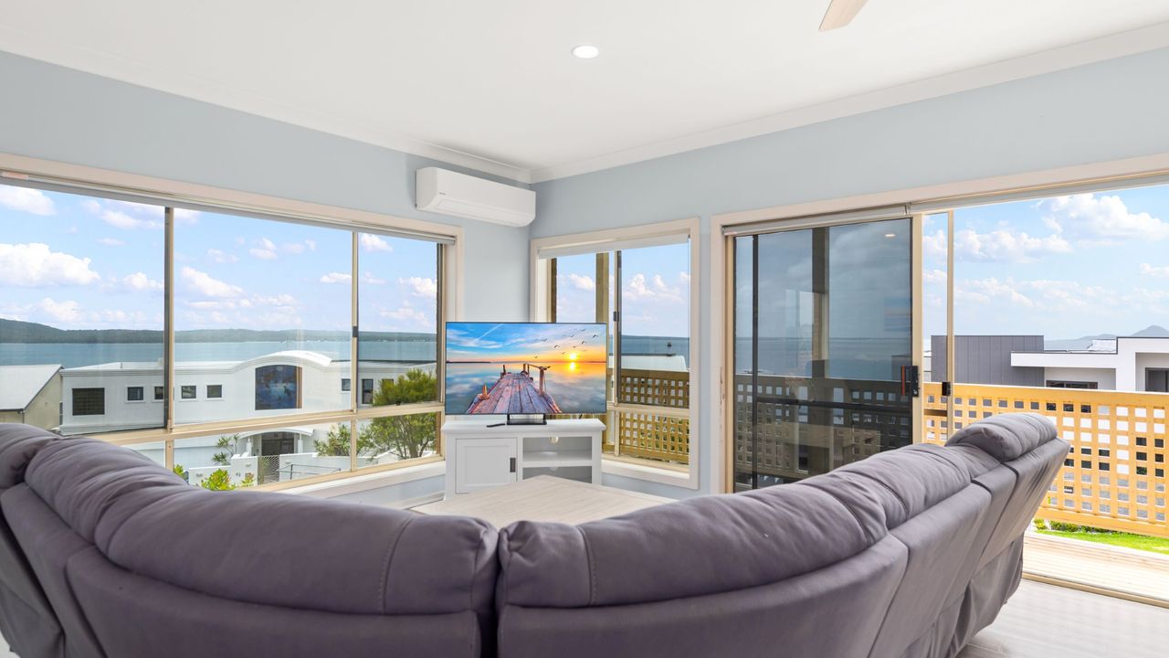 The main living room leads to an expansive balcony, a perfect spot to bask in the stunning water views.