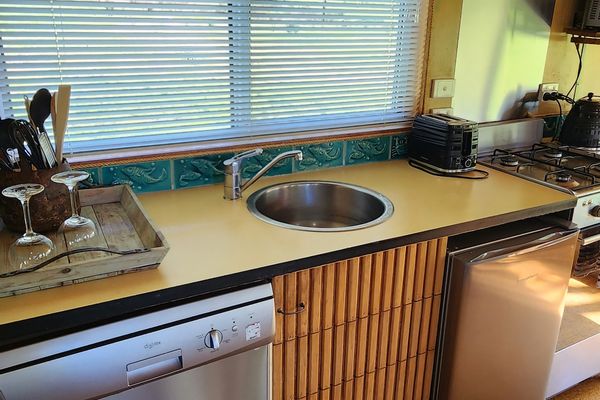 Kitchen area with sink, dishwasher, oven, stovetop and fridge. 