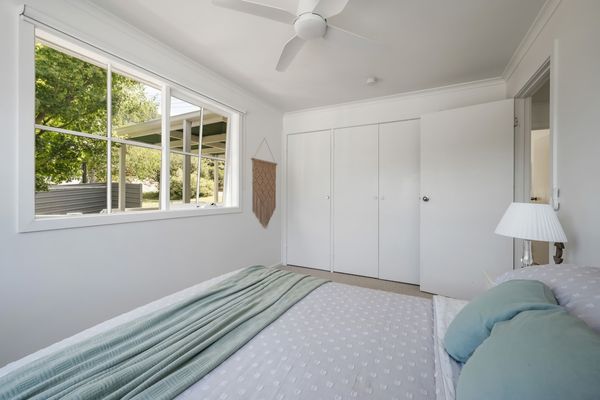 Spacious room with double bed, built in wardrobe, ceiling fan, bedside tables with lamps and lush carpets. 