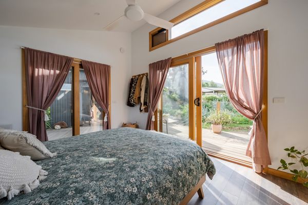 Bedroom with queen bed, ceiling fan and clothes hanging rack. Direct access to the front porch. This room is not attached to the main kitchen /living, you will need to walk along the deck to enter the kitchen area (Deck is not under cover)