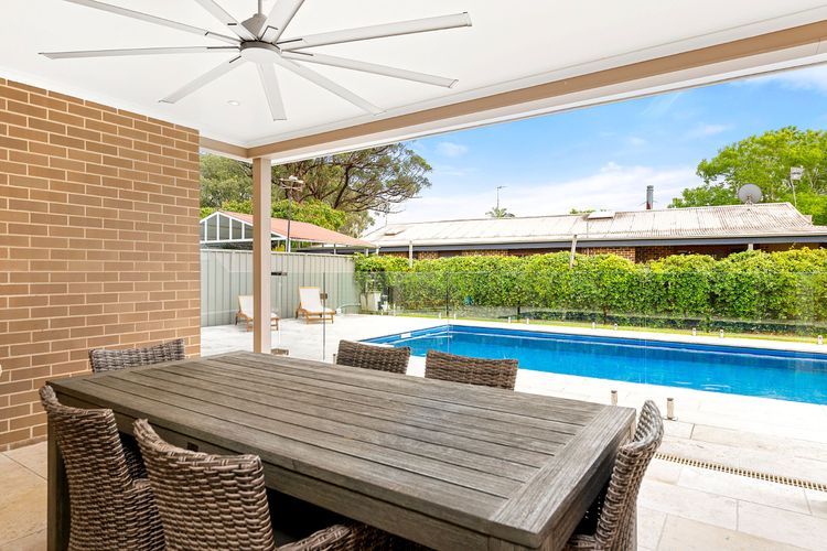 Shaded outdoor dining area by the pool, where you can set up a sunny breakfast or snacks as your family have fun.