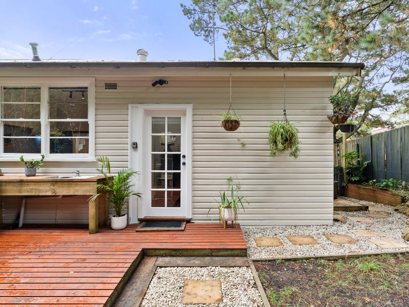 Backyard Retreat: Enjoy the serene outdoor space with a cozy fire pit and seating area surrounded by lush greenery.