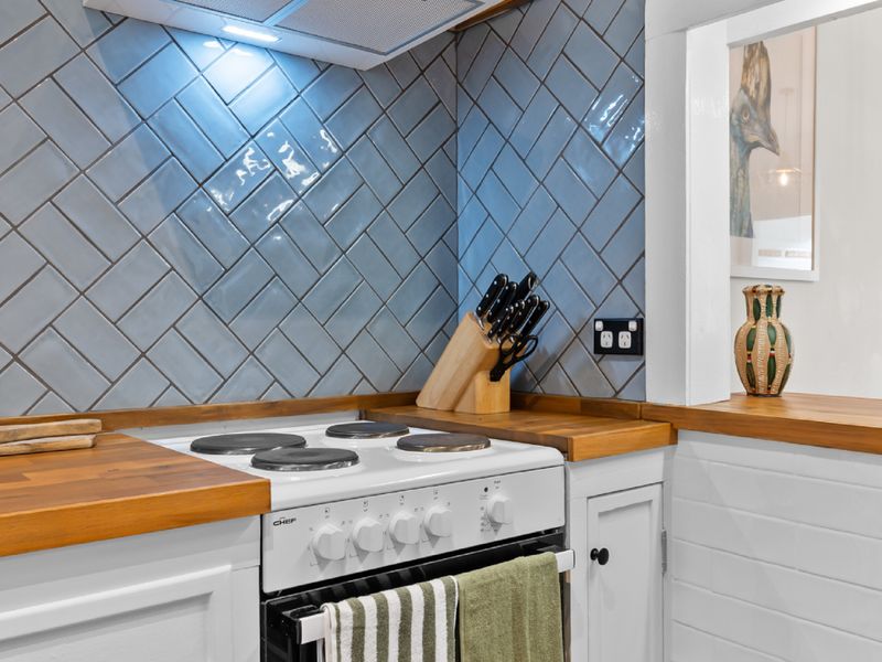 Cozy kitchen space with sleek appliances and wood accents.