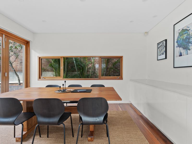 Natural light floods the dining room with a stunning green view.