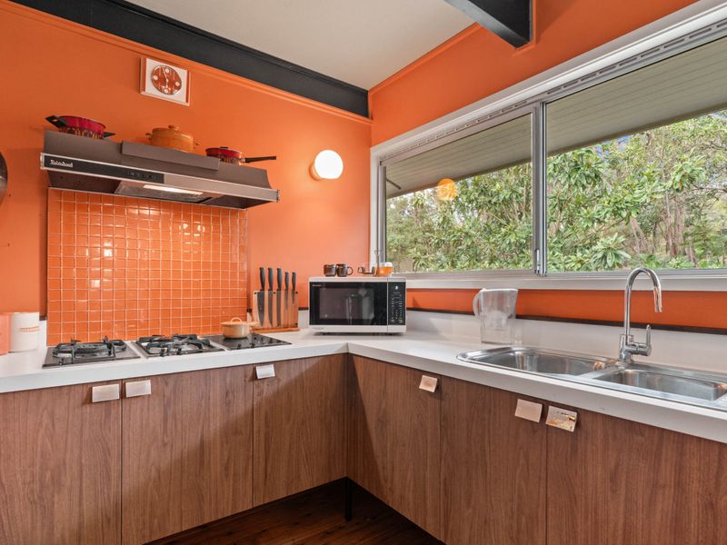 A splash of orange and a touch of nostalgia – this kitchen is a design dream.