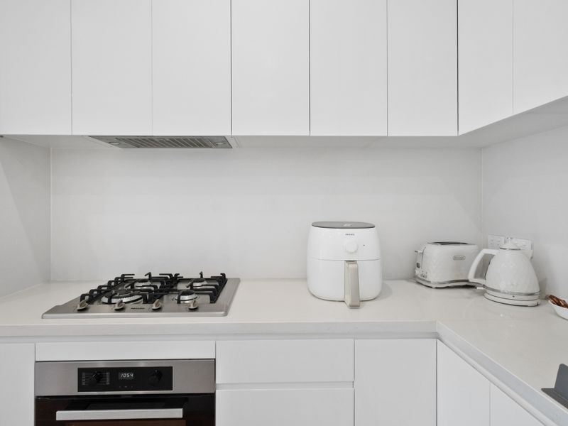 Where culinary adventures begin: A pristine kitchen featuring essential appliances.