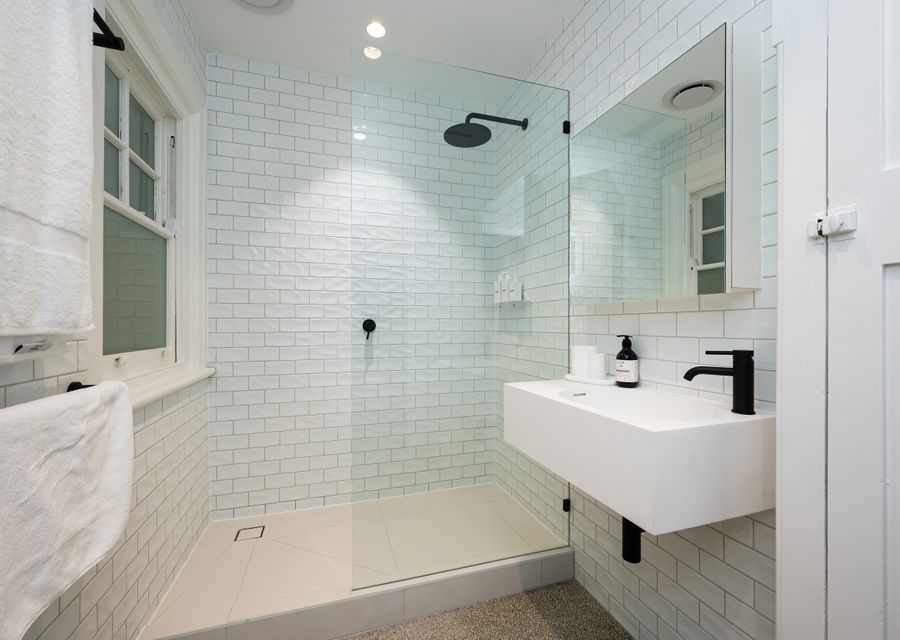 Family bathroom with large step in rain shower and single vanity.