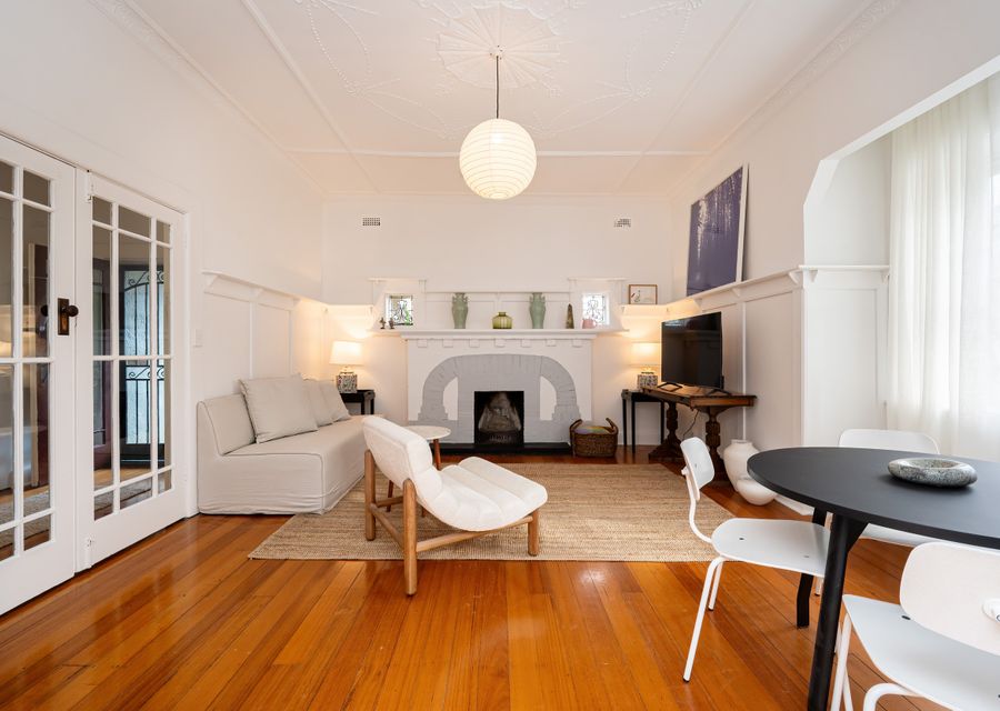 Light, bright living dining with plenty of seating, smart TV and ornamental fire place