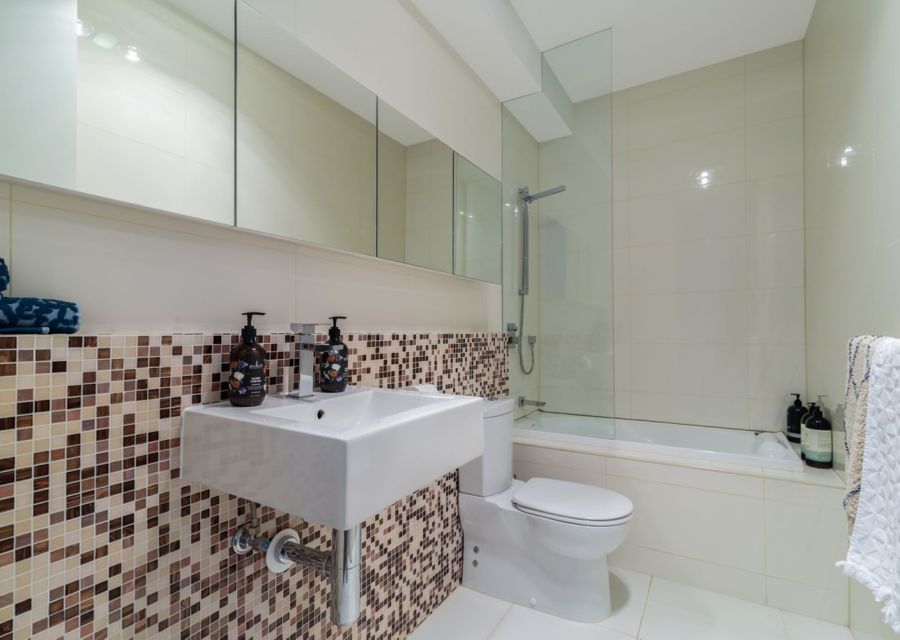 Main bathroom, with vanity,  shower over bath and toilet.