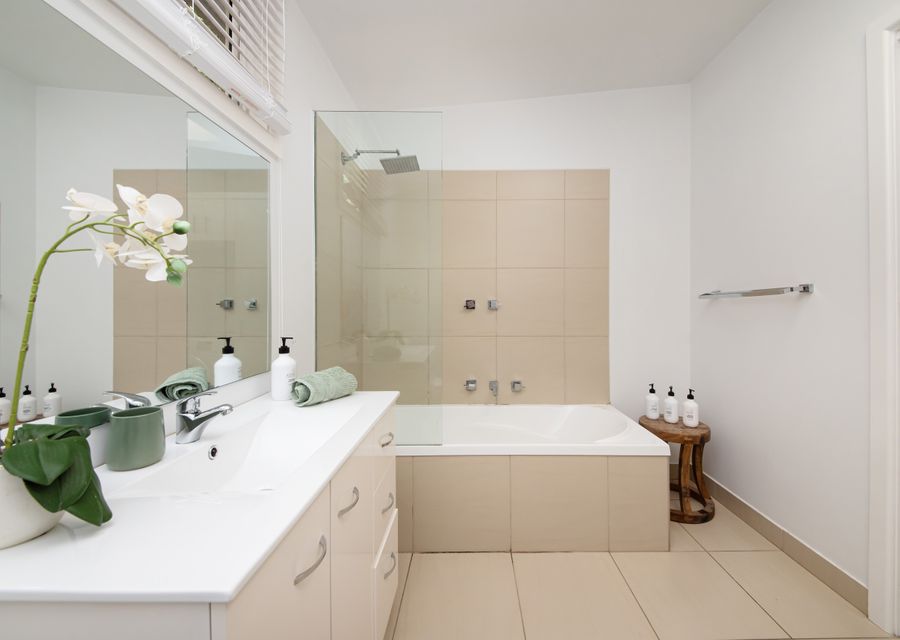 Spacious bathroom/ laundry with shower over bath / toilet and washing machine